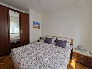 a bedroom with a large bed with blue pillows at Apartment Sole Dorato in Rijeka