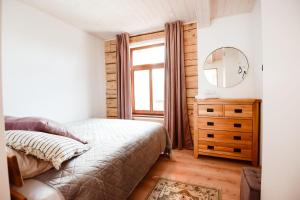 a bedroom with a bed and a mirror and a dresser at MiMaMo in Põlva