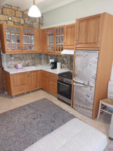 a kitchen with wooden cabinets and a stove top oven at The Stone Heaven in Galíni