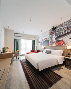 a bedroom with a large white bed and a desk at Livetour Hotel Luogang Science City Guangzhou in Guangzhou
