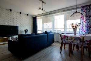 - un salon avec un canapé bleu et une table dans l'établissement Apartament Cztery Pory Roku w Giżycku, à Giżycko