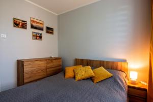 - une chambre avec un lit et 2 oreillers jaunes dans l'établissement Apartament Cztery Pory Roku w Giżycku, à Giżycko