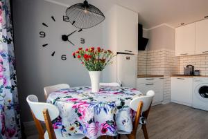 - une table à manger avec un vase de fleurs dans l'établissement Apartament Cztery Pory Roku w Giżycku, à Giżycko