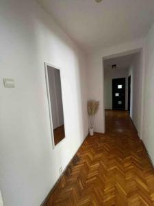 una camera con pareti bianche e pavimento in legno di Apartament zonă centrală Punctele cardinale -Take Ionescu Timișoara a Timişoara