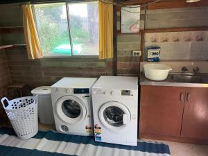 a kitchen with a washing machine and a sink at Bermagui Breeze Holiday House 5 bedroom 18-20 Mumbulla Street - Bermagui in Bermagui