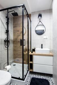La salle de bains est pourvue d'une douche, de toilettes et d'un lavabo. dans l'établissement Apartament Cztery Pory Roku w Giżycku, à Giżycko