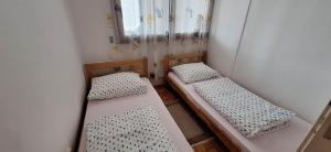 een kleine kamer met 2 bedden en een spiegel bij Apartman UNA Travnik in Travnik