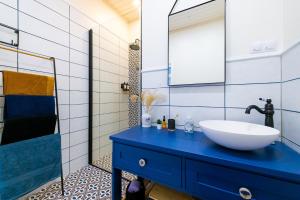 a bathroom with a blue sink and a mirror at Haapsalu OldTown apartment in Haapsalu