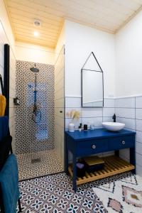 ein Badezimmer mit einem blauen Waschbecken und einer Dusche in der Unterkunft Haapsalu OldTown apartment in Haapsalu