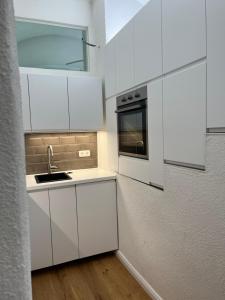 a kitchen with white cabinets and a sink at Altstadtjuwel in Gmunden am Traunsee in Gmunden