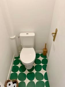La salle de bains est pourvue de toilettes avec un sol vert et blanc. dans l'établissement Cosy, calm 70m2, 2 bedroom flat., à Paris