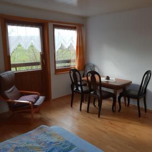 Zimmer mit einem Tisch, Stühlen und einem Bett in der Unterkunft Ferienhaus Rhönspaß in Mosbach