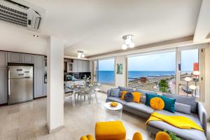 ein Wohnzimmer mit einem Sofa und eine Küche mit Meerblick in der Unterkunft Mackenzie Beachfront Eftyhia Suite in Larnaka