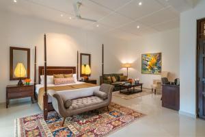 a bedroom with a king sized bed and a living room at Ceylo Villas in Bentota