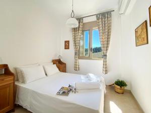 a bedroom with a white bed and a window at Villa Julia in Sani Beach