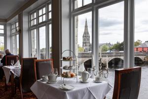 a table in a restaurant with a view of a bridge at Ballina Manor Hotel in Ballina