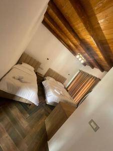 two beds in a attic bedroom with a balcony at Guest House Bracaj in Çorovodë
