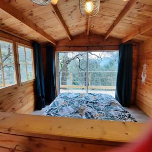 a bedroom with a bed in a room with a window at Chalet Zenitude in Breil-sur-Roya