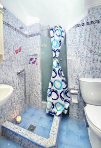 a shower in a bathroom with a toilet and a shower curtain at Villa Julia in Sani Beach +11 photos