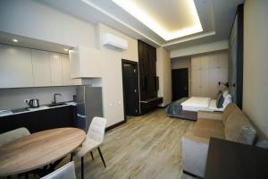 a kitchen and living room with a bed and a table at Soho Apart Hotel in Yerevan