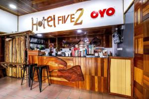 a restaurant with a bar with a hotelagencyz sign at OYO 210 Hotel Five 2 in Kota Kinabalu