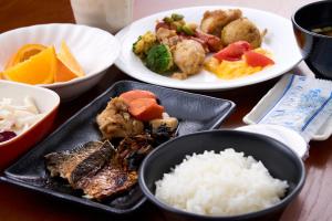 a table topped with plates of food and rice at The Celecton Kitamoto Ekimae in Kitamoto