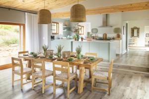 Boschendal Farm Estate في فرانستشوك: مطبخ وغرفة طعام مع طاولة وكراسي خشبية