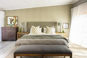 um quarto com uma cama grande e almofadas brancas em Boschendal Farm Estate em Franschhoek