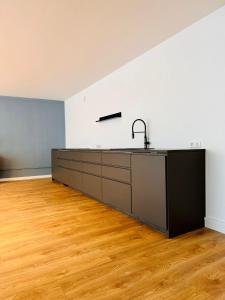 una cocina vacía con fregadero y suelo de madera en Lofts V26 en Essen