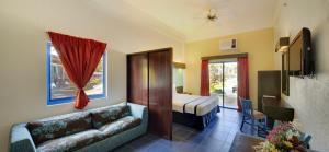 una camera d'albergo con divano e letto di Microtel by Wyndham Puerto Princesa a Città di Puerto Princesa