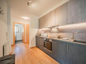 uma cozinha com electrodomésticos em aço inoxidável e pisos em madeira em Apartments home Gamper Brixen im Thale em Brixen im Thale