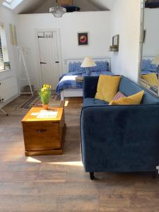 a living room with a blue couch and a bed at Tigh Noor - Escape to Kinvara by the sea! in Galway