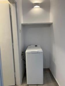 Un baño con un refrigerador blanco y una luz. en Naxian Castle Gem Studio, en Naxos Chora