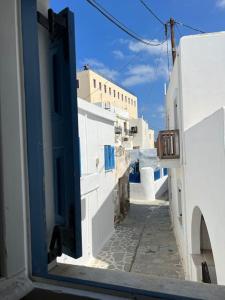 Una vista de un callejón con edificios blancos y una puerta azul. en Naxian Castle Gem Studio, en Naxos Chora