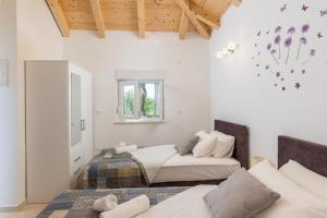 een slaapkamer met 2 bedden en een raam bij Apartments Roza in Mlini