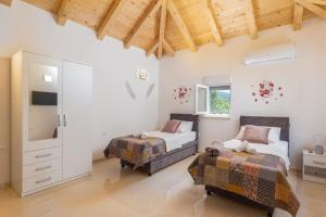a bedroom with two beds and a tv at Apartments Roza in Mlini