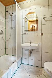 uma casa de banho com um lavatório, um chuveiro e um WC. em Abro em Augustów