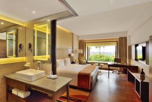 a hotel room with a bed and a sink at Courtyard by Marriott Raipur in Raipur