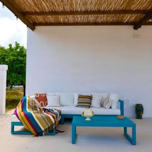 a white couch with pillows and a blue coffee table at Masseria Pezze Galere-La Casa del Fico con piscina idromassaggio privata in Fasano