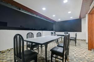 a conference room with tables and chairs and a chalkboard at Aceotel Inn Flamingo Vijay Nagar in Indore