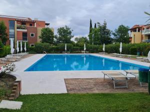 una piscina in un cortile con sedie e tavolo di Elegante appartamento con vista a Cavallino Venezia a Cavallino-Treporti