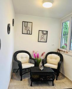 two chairs and a table in a living room at Mitella studio apartman in Solin