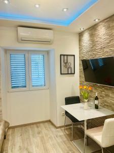 a living room with a table and a tv at Mitella studio apartman in Solin