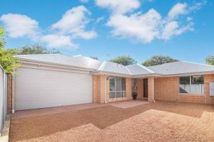 una casa de ladrillo con garaje blanco en Duke Cottage - pet friendly near beach., en Busselton