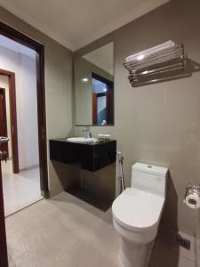 a bathroom with a white toilet and a sink at LE SEMAR HOTEL KARAWACI in Dahung