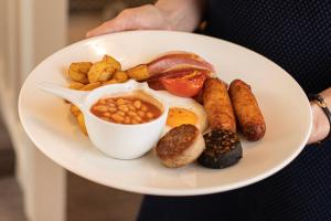 a person holding a plate of breakfast food at Ballina Manor Hotel in Ballina