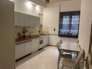 a kitchen with white cabinets and a table and a window at Apartment On Botanikuri 17 in Tbilisi City