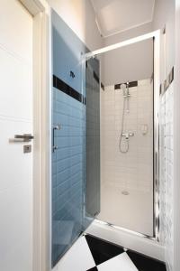 a bathroom with a shower with a glass door at By Monte Apartment in Sopot