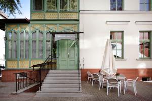 a building with a green door and tables and chairs at By Monte Apartment in Sopot