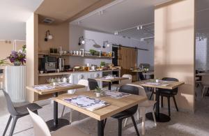 a restaurant with wooden tables and chairs and a kitchen at Zacisze Lubiatowo in Lubiatowo